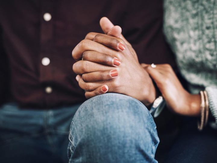 Close up of male and female holding hands