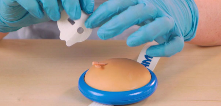 Person wearing disposable gloves holding an insuflon