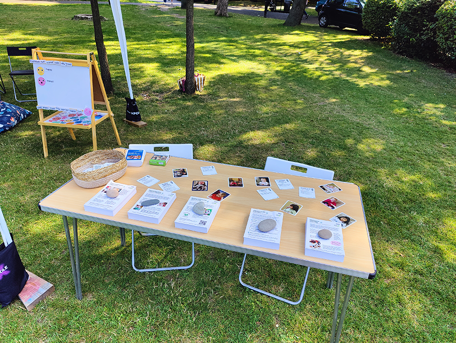 A table laid out with lots of pictures of babies and leaflets laying on top of it.