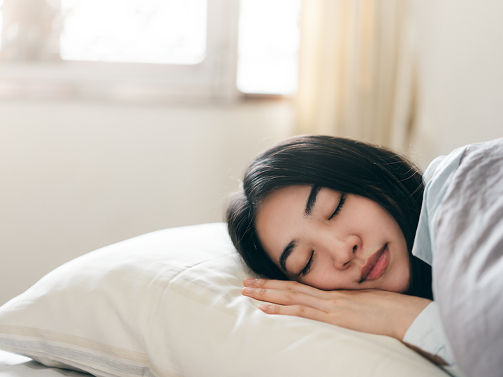 teenager sleeping on pillow with bright daylight outside