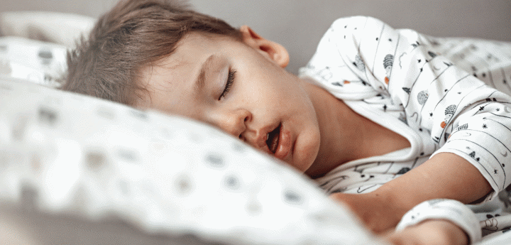 boy sleeping in his bed on his side with his mouth slightly open