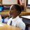 10 year old boy sitting in classroom at desk, looking up