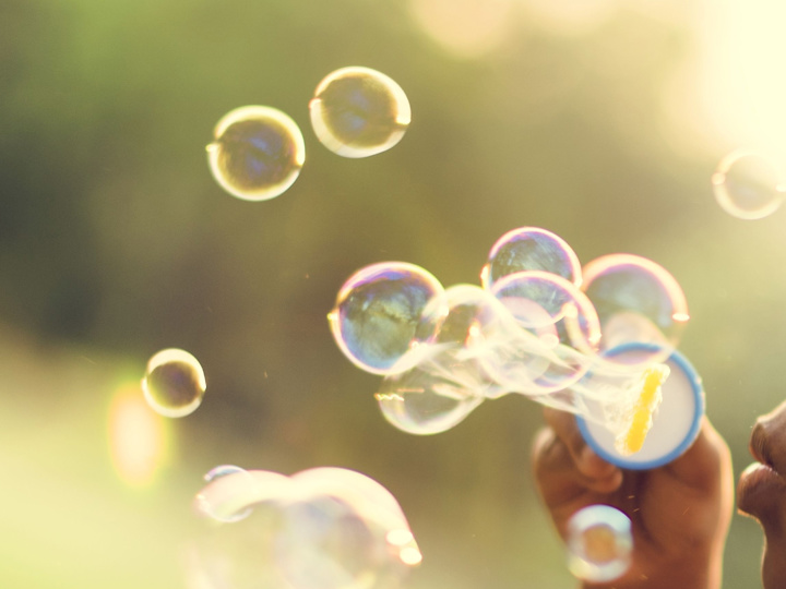 Young child blowing bubbles outdoors