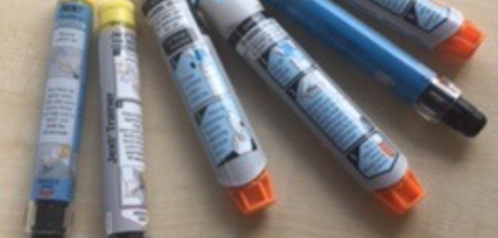 6 adrenaline auto injectors lying on a table