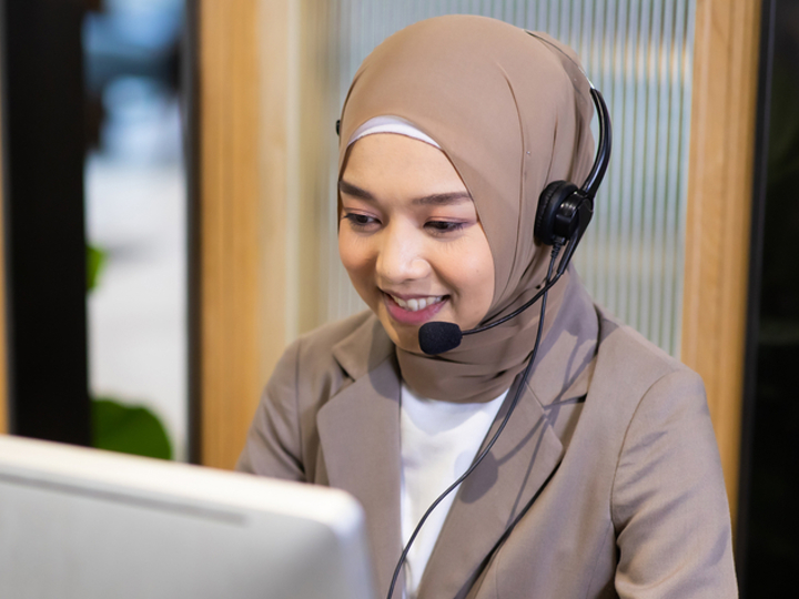 Administrator sitting at a desk on the phone using a headset