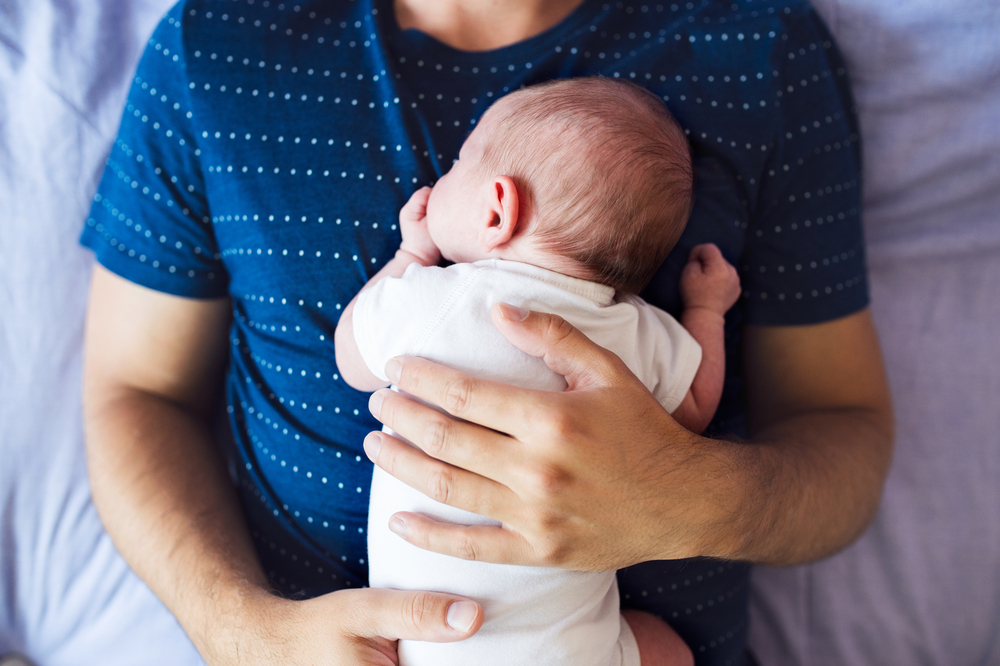 baby lying on man's chest