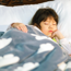 child sleeping in bed with cloud blanket