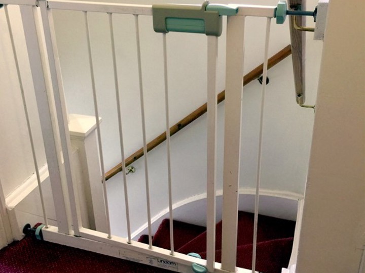 Stair gate in a home at the top of the stairs