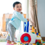 Boy toddler standing and pushing a toy in a living room