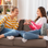 2 teenage girls talking on sofa