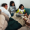 family reading a book in bed, two adults and two children