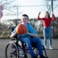 Boy sat in a wheelchair playing basketball